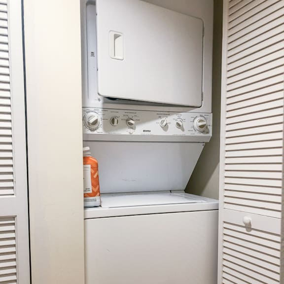 a white washing machine is in a small laundry room.
