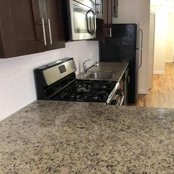 a kitchen with granite countertops and a stove and a refrigerator
