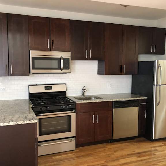 a kitchen with wooden cabinets and stainless steel appliances and granite counter tops