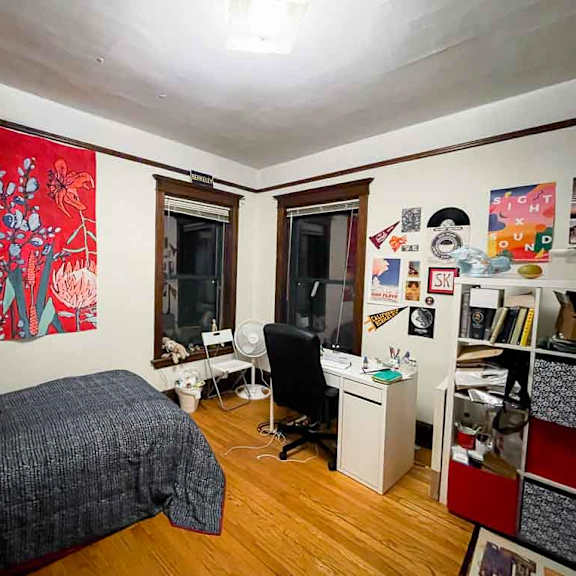 a bedroom with a bed, desk, and chair.