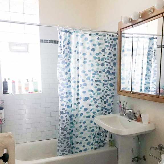 a white sink is under a mirror in a bathroom with a black and white floor.