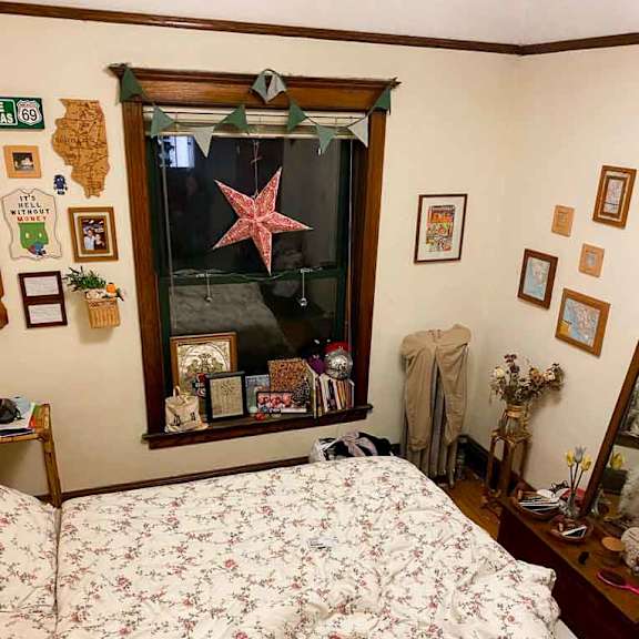 a bedroom with a floral bedspread and a mirror with a starfish decoration.