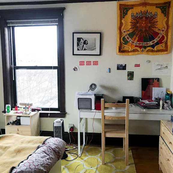 a room with a bed, desk, and chair.