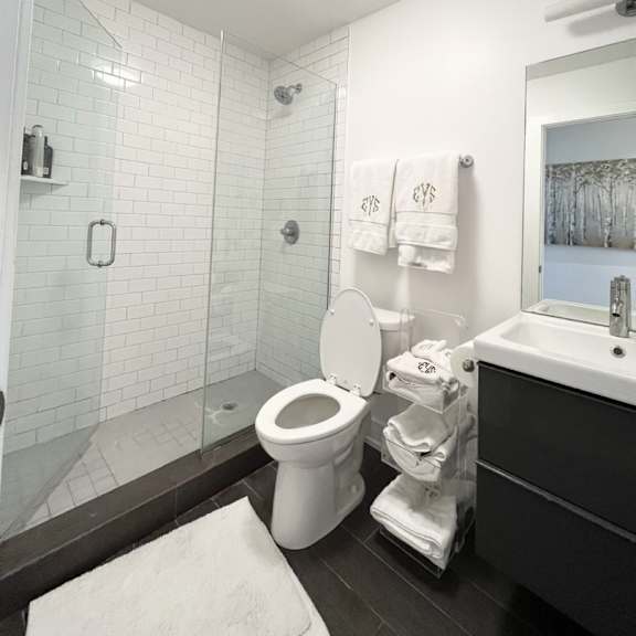 a white toilet in a bathroom with a glass shower door.