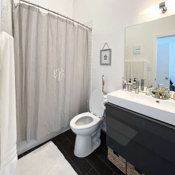 a bathroom with a toilet, sink, and shower curtain.
