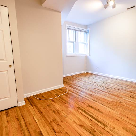 a room with wooden flooring and a window.