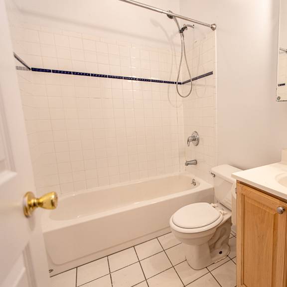 a white bathroom with a toilet, sink, and bathtub.