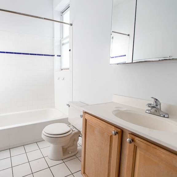 a white bathroom with a toilet, sink, and bathtub.