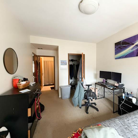 a bedroom with a bed, desk, and chair.