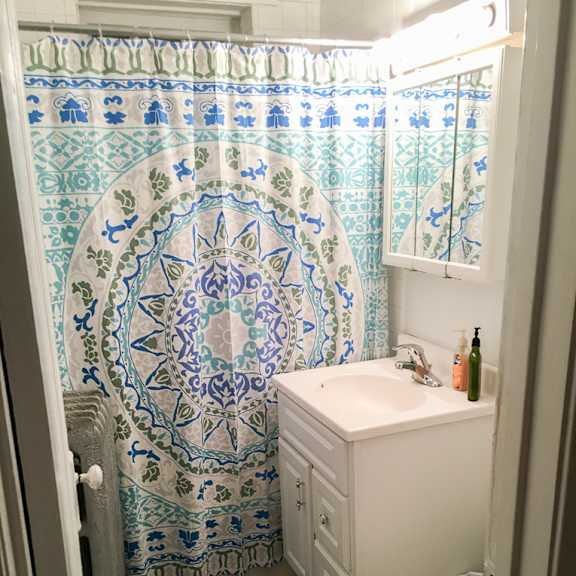a bathroom with a toilet, sink, and shower curtain.
