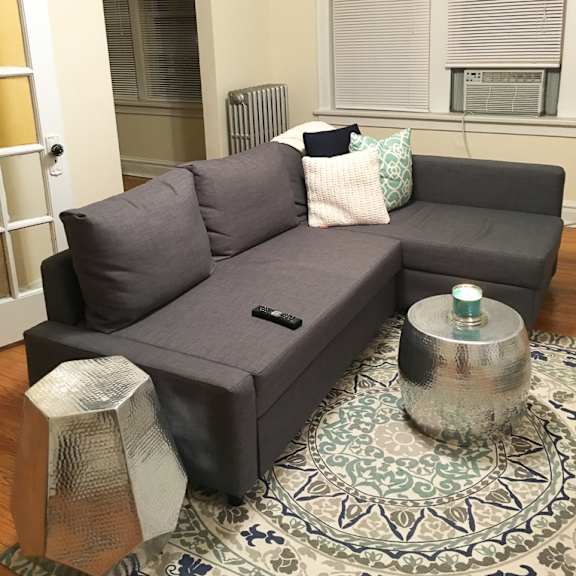 a grey couch with a silver table in front of it.