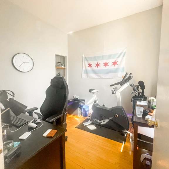 a room with a clock on the wall and a chicago flag hanging.
