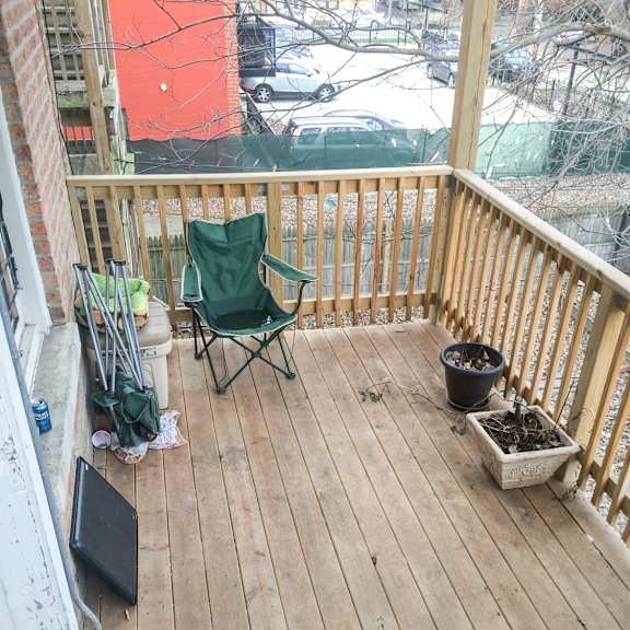a balcony with a green chair and a planter box.