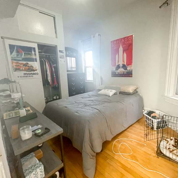 a bedroom with a bed, a dresser, and a window.