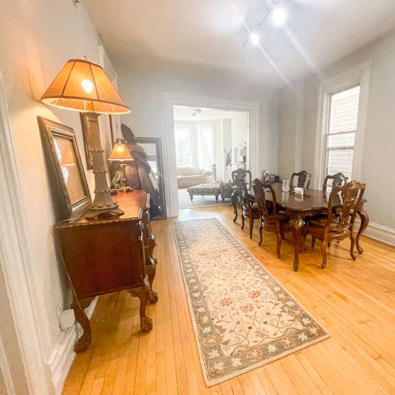 a room with a wooden floor and a rug in the middle.