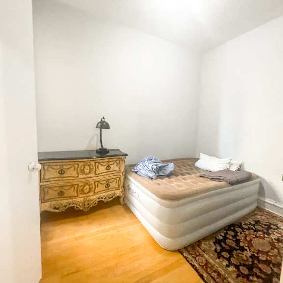 a bedroom with a bed, dresser, and rug.