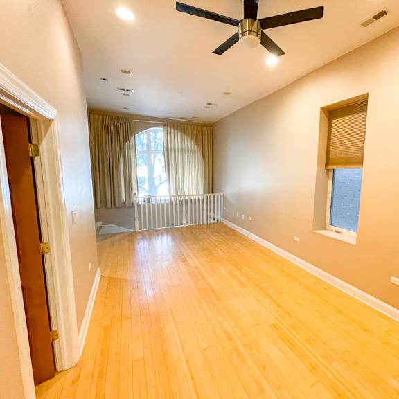 a room with wooden floors and a ceiling fan.