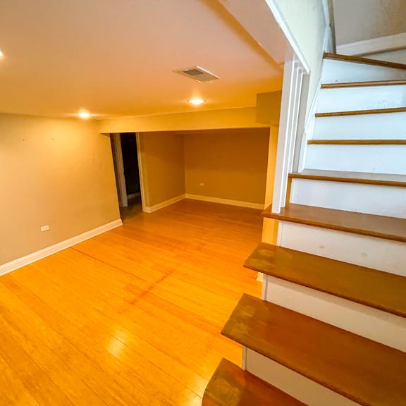 a room with wooden floors and a staircase.