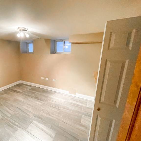 a room with a white door and a light on the ceiling.