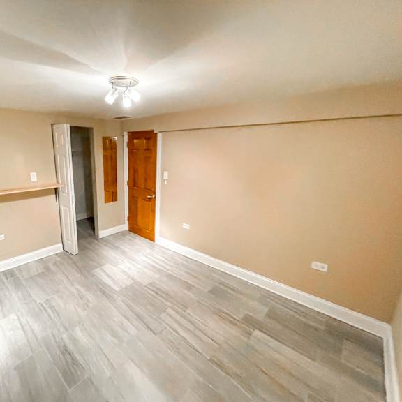 a room with a wooden door and a grey floor.