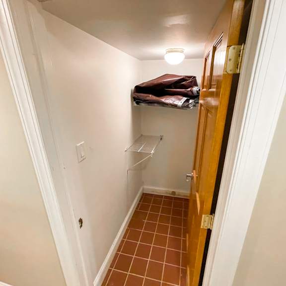 a hallway with a brown door and a white wall.