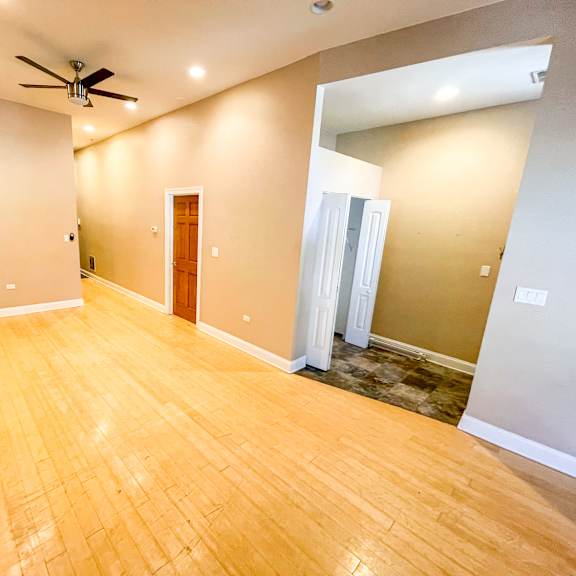 a room with a wooden floor and a ceiling fan.