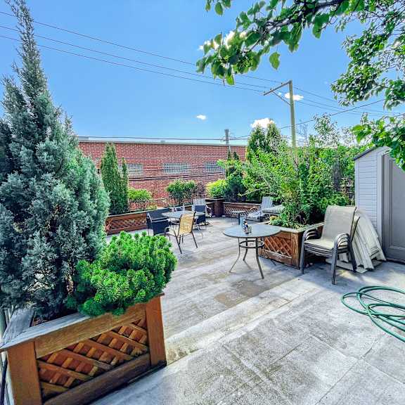 a patio with a table and chairs surrounded by trees.