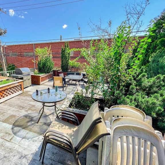a patio with a table and chairs overlooking a brick wall.