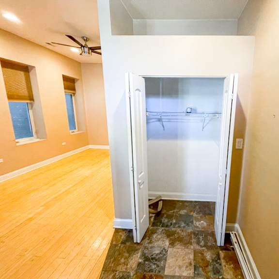 a room with a ceiling fan and a doorway leading to another room.