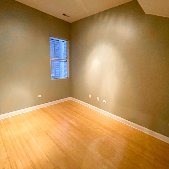 a room with a wooden floor and a window.