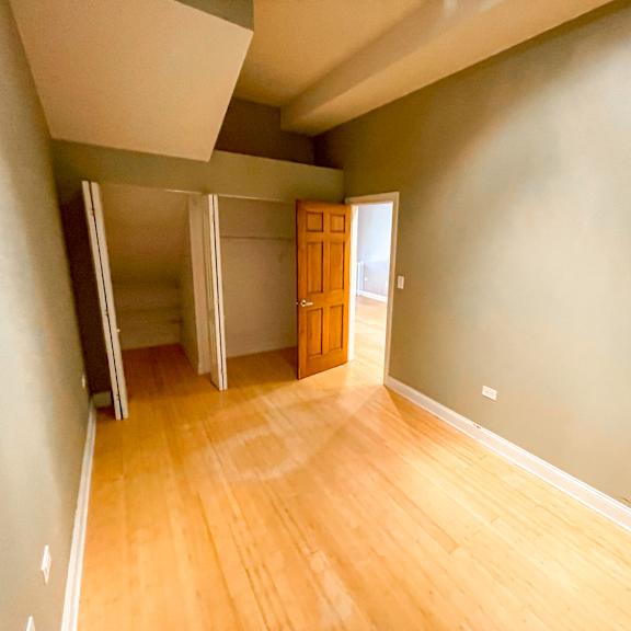a room with a wooden floor and a brown door.