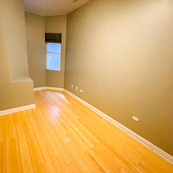 a room with wooden flooring and a window.