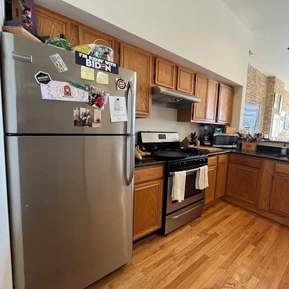 a kitchen with a refrigerator covered in magnets and a stove top oven.