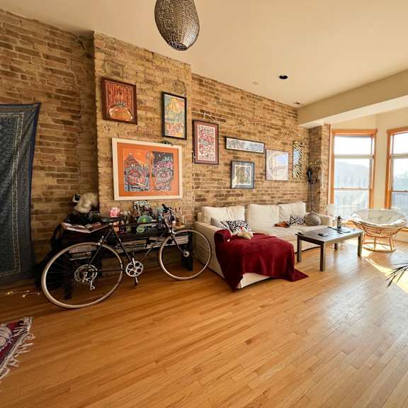 a living room with a brick wall and a bicycle.
