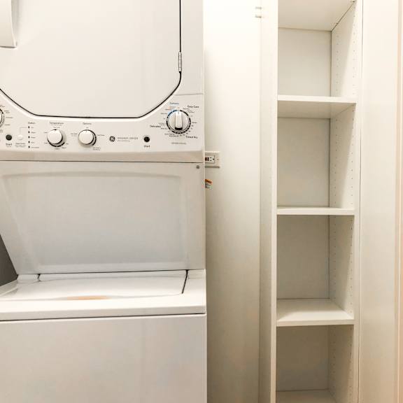 a white oven with a towel hanging on the handle is next to a white toilet.