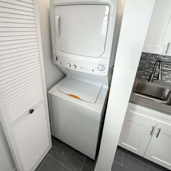 a white washing machine in a small laundry room.