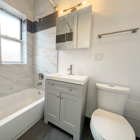 a white bathroom with a tub, toilet, and sink.