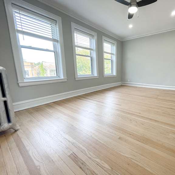 a room with wooden flooring and a ceiling fan.