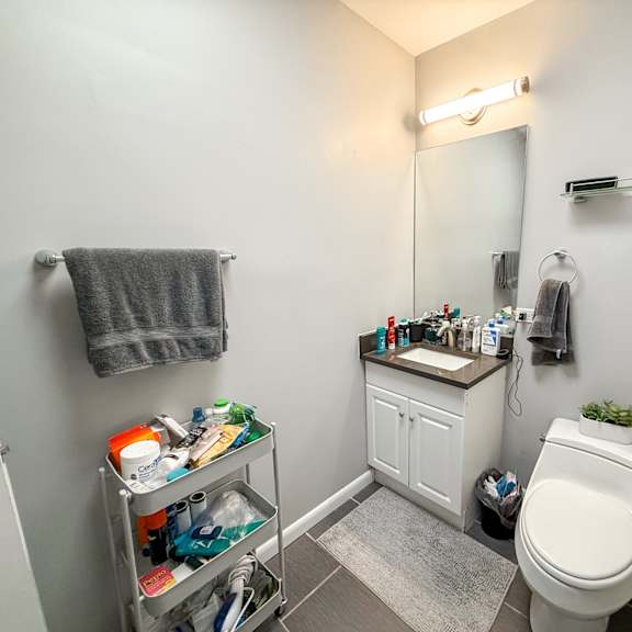 a bathroom with a toilet, sink, and a mirror.
