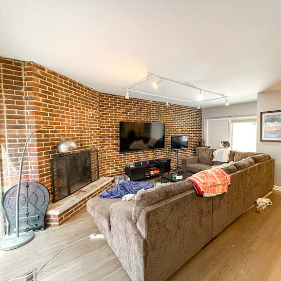 a living room with a couch, a fireplace, and a television.