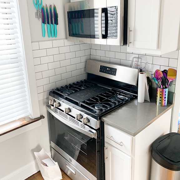 a kitchen with a stove and a microwave above it.