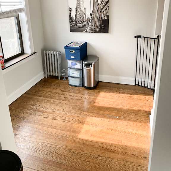 a room with a wooden floor and a picture of a clock on the wall.