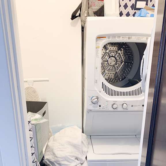 a white dishwasher with a blue basket in front of it.