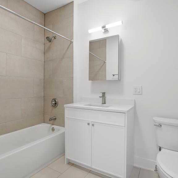 a white bathroom with a tub, sink, and toilet.