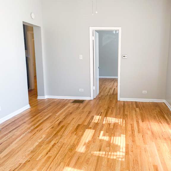 a room with wooden flooring and a doorway leading to another room.