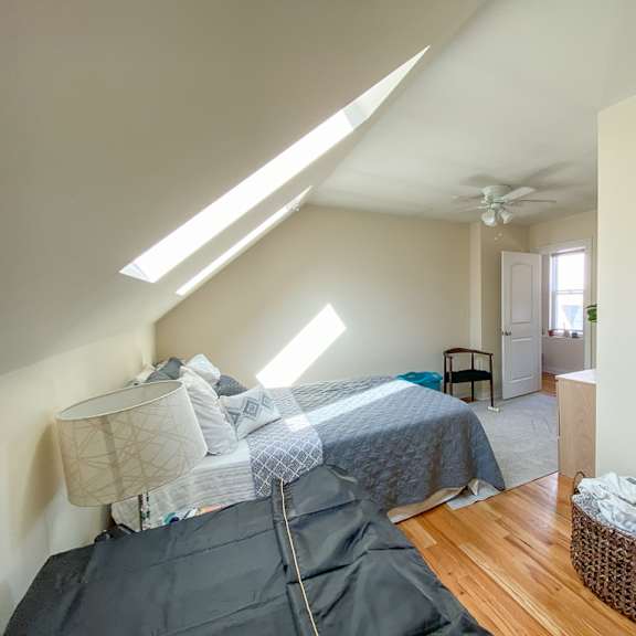 a room with a bed and a basket on the floor.