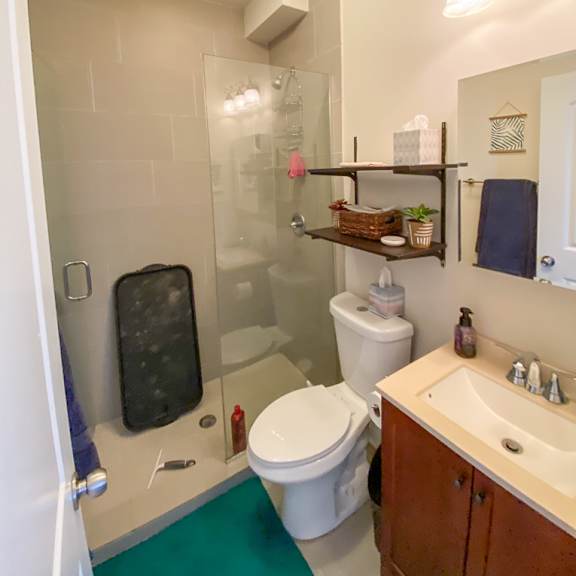 a bathroom with a toilet, sink, and shower.