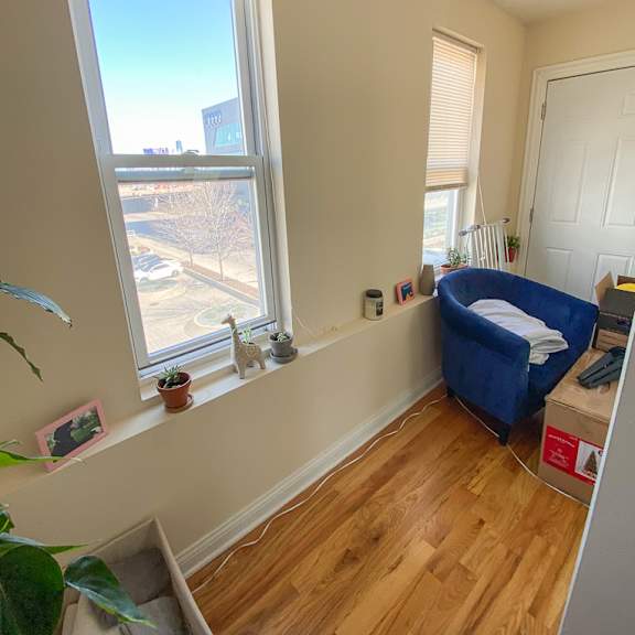 a room with a window and a blue chair.