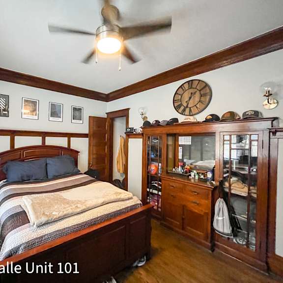a bedroom with a bed, dresser, and ceiling fan.