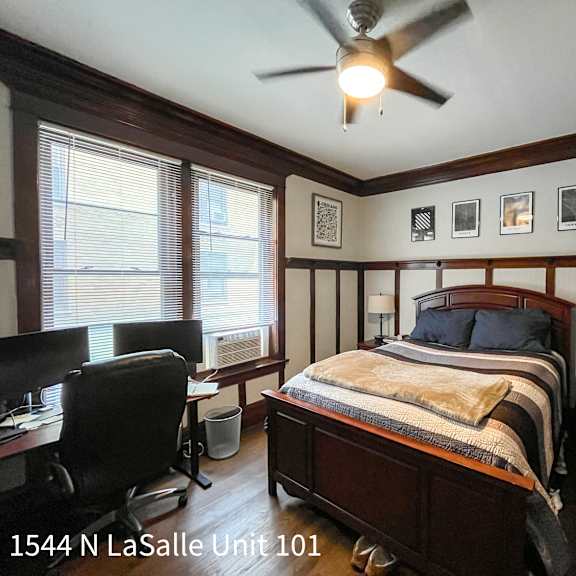 a bedroom with a bed, desk, and chair.